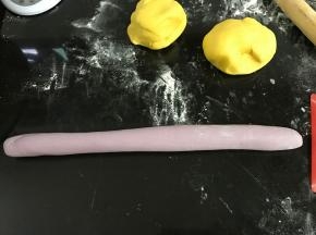 取一紫色面团搓长。