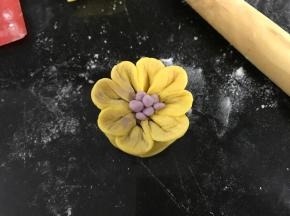 取一点点不同色的面团搓成小圆放在花瓣中间当花蕊。