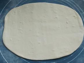 醒发好的面团，取出一块，然后擀成圆饼状