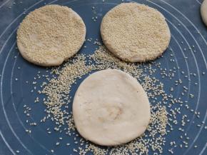 在烧饼的表面刷一层水，然后沾满芝麻