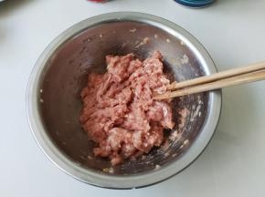 先把猪肉切小块用料理机打成肉馅，然后放入一勺盐、一勺生抽、一茶匙香油和葱末，调匀备用