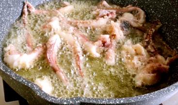 锅中油烧热，鱿鱼须下锅，快速打散