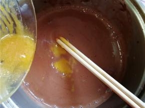 14.然后将蛋黄液倒入混合好的巧克力浆中，搅拌均匀；