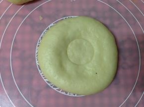 将包好的椰蓉包按扁，中间用瓶瓶盖儿压一个印儿
