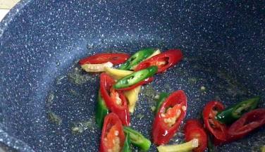 锅留底油，爆香姜丝、青红辣椒