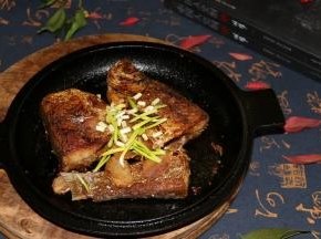 温度起来后，小火把鱼煎熟，两面时不时翻面，以免煎糊，铸铁锅特别好用！差不多煎熟后，放入碗里的花椒粒和姜片，老抽生抽到在碗里，搅拌均匀，将火开大点，往鱼身上浇，香醋沿锅边一呛，鱼身也倒一些，然后翻面