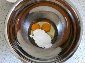 鸡蛋打入容器内，滴入4滴柠檬汁，倒入糖粉