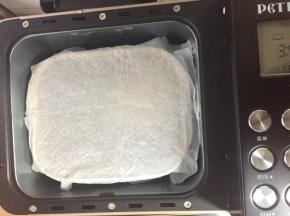 面团放入面包机内（或温暖地方），厨房纸吸湿稍拧干水分（不滴水即可）盖在面包桶上方，盖上面包机盖子进行发酵50分钟