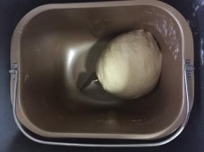 此时面团会比较粘手，手抹上少许玉米油，将面团整个取出整形成光滑圆形面团