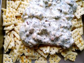 将面包桶里的混合物倒入盛有苏打饼干的烤盘