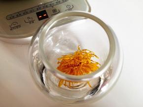 6．	将干菊花放在一个干净的空杯子里，