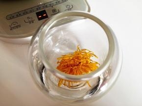 6．	将干菊花放在一个干净的空杯子里，