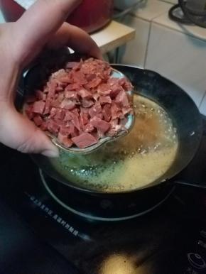 再下火腿碎，至这三样食材都脱水，变成金黄色。