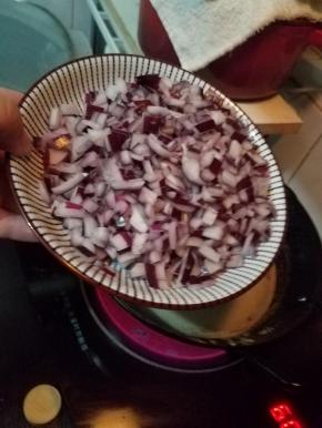 保持油锅中小火加热，倒入洋葱碎，继续炸5分钟左右，至洋葱变黄。