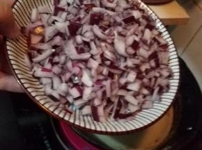 保持油锅中小火加热，倒入洋葱碎，继续炸5分钟左右，至洋葱变黄。
