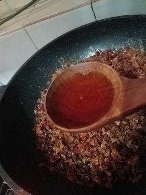 另一个炉灶开小火，往捞出的干贝、海米和火腿中倒入4大勺料酒、2大勺生抽、5大勺蚝油、一大勺糖，和之前蒸干贝和火腿出的汤汁，拌匀后小火熬煮。