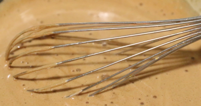 将沸腾的巧克力牛奶沿着装蛋黄容器的边缘慢慢倒入，边倒边电动转圈搅打匀。（沸腾的巧克力液倒入蛋黄中起到一个杀菌的做用，）