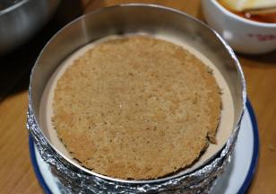 倒入慕斯糊，没过蛋糕片后再依次放入刷过酒的第二片蛋糕片，再次倒入慕斯糊。