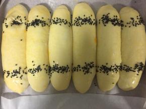 二发后的面团表面刷全蛋液，洒芝麻