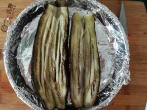 把烤好的茄子，用刀切开，然后划几刀。