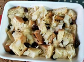 r吐司放进焗饭碗里面，加入一些蔓越莓干，均匀的倒入布丁液，面上再撒些杏仁片