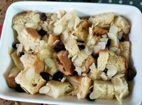 r吐司放进焗饭碗里面，加入一些蔓越莓干，均匀的倒入布丁液，面上再撒些杏仁片