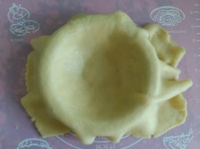 擀好的皮盖入模具中，边缘和底部压平。