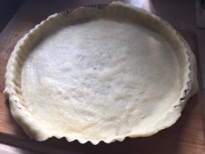 取出面团，将面团擀成和9寸模具大一小圈的薄饼片，平铺模具上方，整形，修整多余薄片