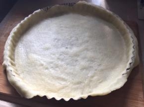 取出面团，将面团擀成和9寸模具大一小圈的薄饼片，平铺模具上方，整形，修整多余薄片