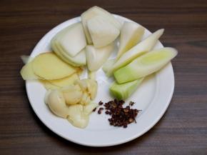 大葱斜切段，大蒜头剥去外皮，生姜切片，花椒冲洗去浮尘。

