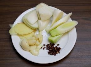 大葱斜切段，大蒜头剥去外皮，生姜切片，花椒冲洗去浮尘。
