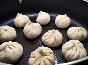 摆放包子，盖上锅盖，开启小火烧热锅底，然后断火。这是进行发酵10分钟。