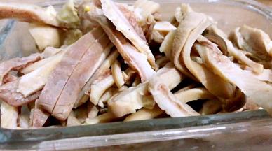 将猪肚洗净后切成条备用（猪肚用面粉搓揉抓里外两面，再用清水洗净，然后放入锅中煮至变色，捞出放凉水中，用刀刮去表皮的污渍和浮油，再冲洗干净）