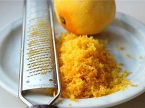 橙子洗干净表皮，用擦屑器擦出橙皮屑，不要白色的部分，会苦。