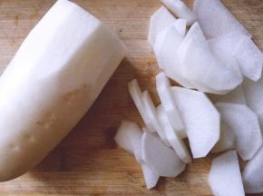 将白萝卜去皮切一半，将其切薄片洗净