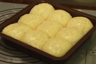 将发酵好的面包胚刷上蛋液，均匀的洒上熟白芝麻