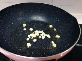 将切碎的大蒜放入锅中