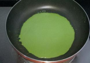 不粘平底锅小火加热，舀适量面糊倒入锅中，转动锅子，使面糊均匀布满整个锅底