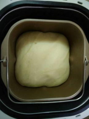 直接在面包机发酵至原来的2倍大，再次启动面包机和面几分钟，相当给面团排气。