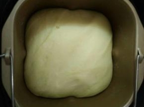 直接在面包机发酵至原来的2倍大，再次启动面包机和面几分钟，相当给面团排气。
