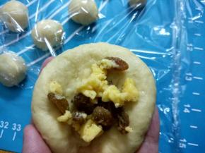 取身体面团排气滚圆压扁包入馅料，包好再次滚圆，放在铺垫锡纸烤架上，盖上保鲜膜。