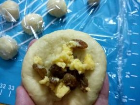 取身体面团排气滚圆压扁包入馅料，包好再次滚圆，放在铺垫锡纸烤架上，盖上保鲜膜。