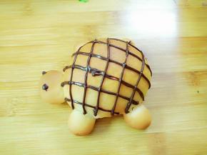 巧克力装入裱花袋隔水融化，剪个小口，在乌龟的背上挤上网格状，点上眼睛，可爱的乌龟就完成了。