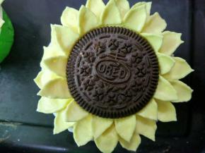 在杯子蛋糕周围裱上二圈花瓣，放上饼干即可