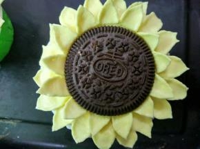 在杯子蛋糕周围裱上二圈花瓣，放上饼干即可