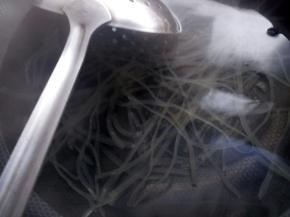 锅中下入薯粉煮软化后捞起，接着下入香菇片烫熟。