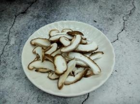 盘里放水，放香菇，用手在水中朝一个方向旋搅，这时香菇表面及菌褶部的泥沙会随着旋搅而落下来，反复旋搅几次，就能彻底把泥沙洗净。香菇切丝