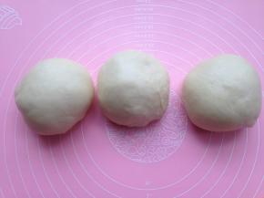 一发后的面团移至揉面垫上排气，然后分割成等量的三份，分别收圆盖保鲜膜静置松弛至少5分钟