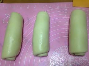 松弛后的面团擀成牛舌状后压薄底边，自上而下卷起