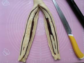 用刀或刮板从面团中间竖着切开，一分为二，顶端留着不要切断